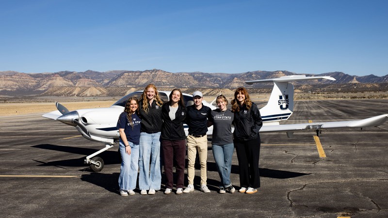 People standing in front of an airplane.