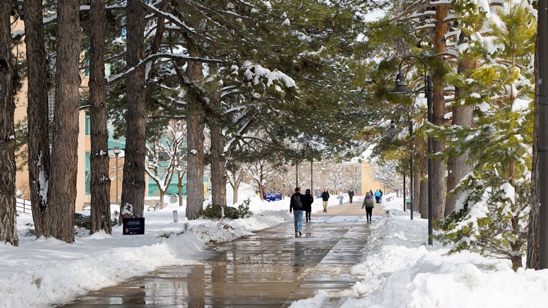 Students walking on a snowy USU Logan campus.