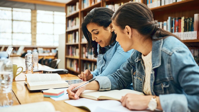 Two women studying in a library.