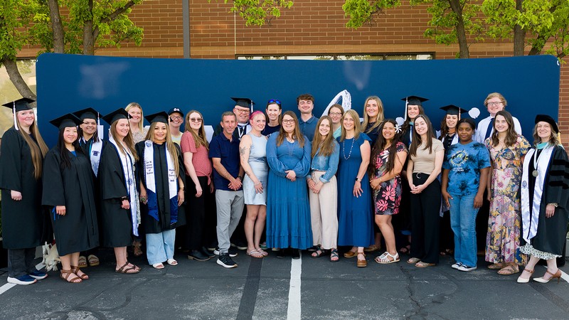 Students pose for a group photograph in front of an "I'm an Aggie" backdrop.