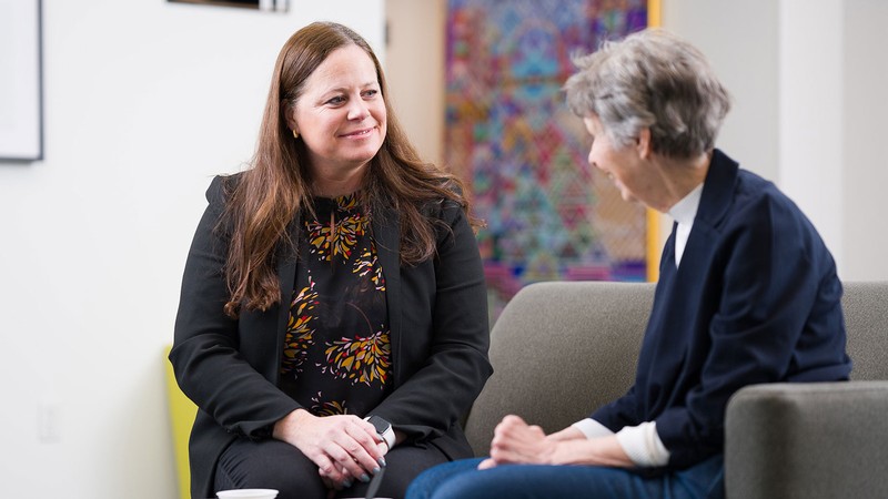 Beth Fauth speaking with an older adult.