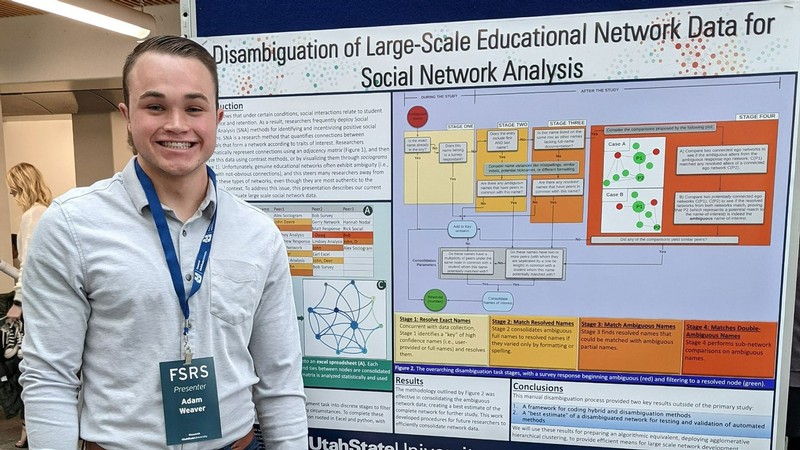 Adam Weaver stands by a poster about his research.