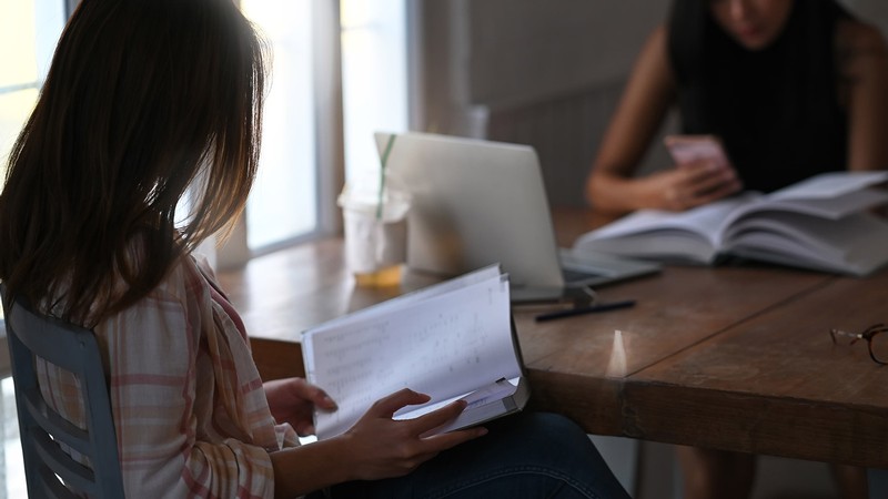 student sits at a table with an advisor.
