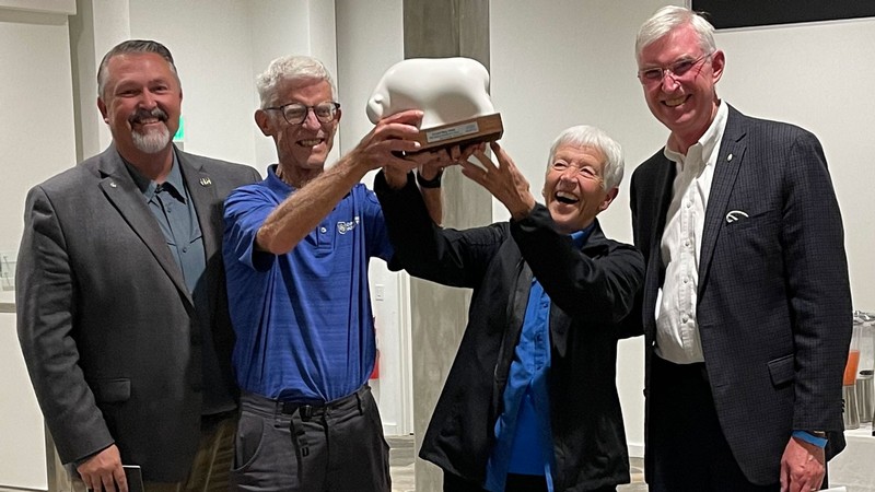 Mary and Art Heers holding a sculpture.