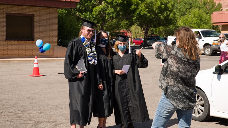 Moab Graduates take a photo with a USU Moab faculty member during the 2021 Commencement.