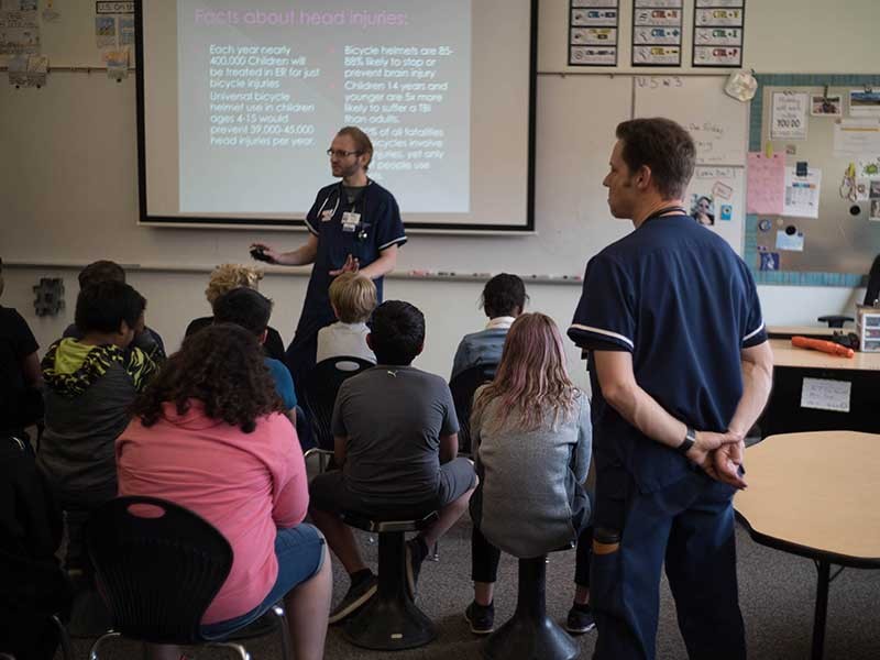 Nursing students Scott Fielding and Mark Weissinger teaching helmet safety.