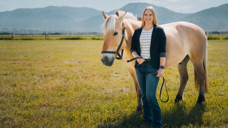 Equine Lecturer Sarah Andersen stands next with a horse in the Cache Valley
