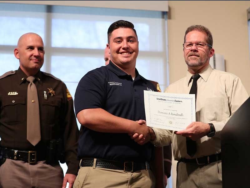 Dominic Rondinelli accepts his Peace Officer Standards Training (POST) certificate from Scott Henrie