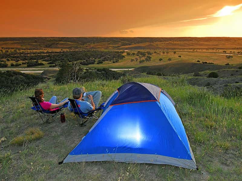 man an woman next to tent in the wilderness