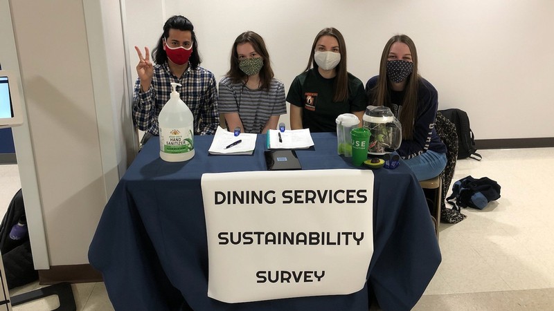 Dining services employees educate students about the survey in the TSC.