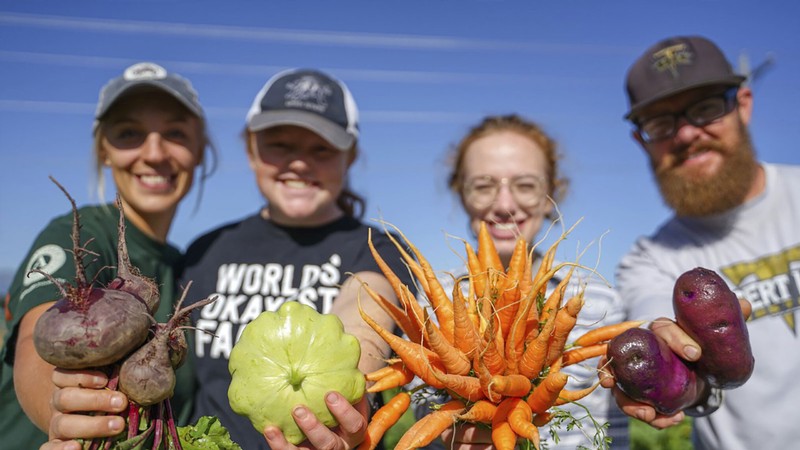 USU dietetics students holding vegetables.