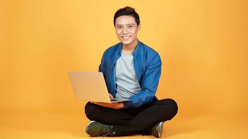 A young man with a laptop.