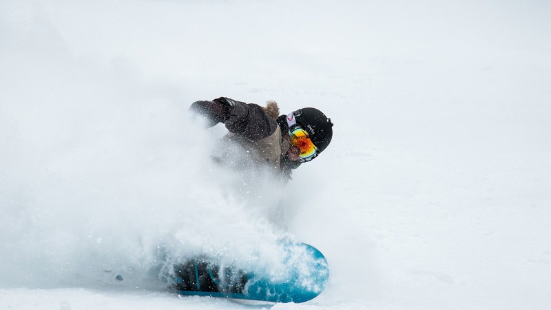 Snowboarder glides down a mountain.