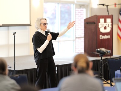 A woman addresses a crowd at a pulpit
