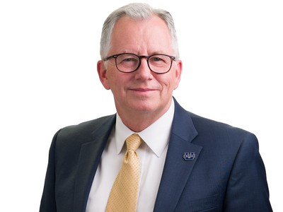 A man poses for a photo with a white background.