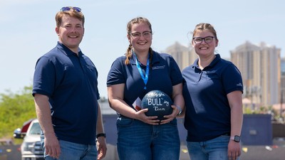 Engineering students hold a concrete ball with Aggie BULL-ing Team written on it.