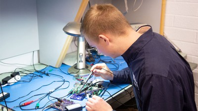 A grad student soldering circuit boards together.