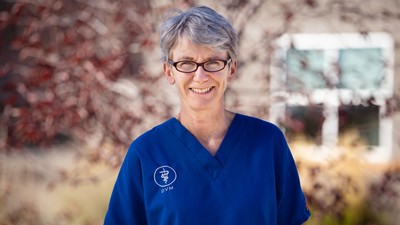 Jane Kelly, wearing medical scrubs, poses for a photograph.
