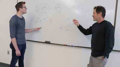 Physicists at whiteboard.