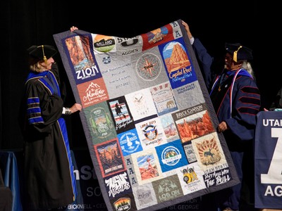 A person holds up a quilt