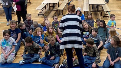K-12 students listen to an engineering student.