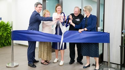 People cutting a giant ribbon.
