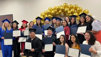 People holding graduation certificates.
