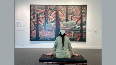 Woman sitting in museum looking at a painting