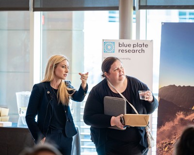 Two people talking at a research presentation.