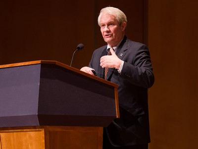 A man stands behind a podium giving a speech.