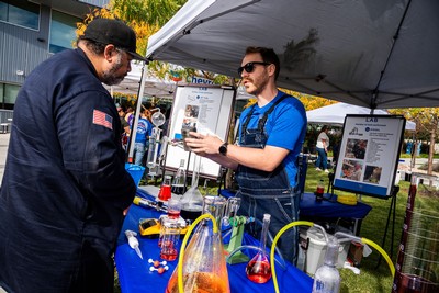 People speaking at a booth during an event.