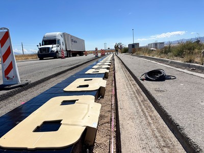 A truck driving by a roadway construction project.