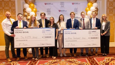 A group of individuals pose for a photograph holding oversized checks.