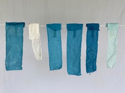 Strips of blue-dyed cloth hanging on a drying line.