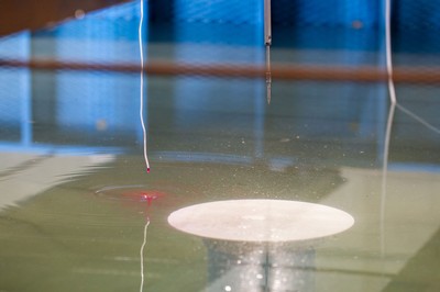 Red dye being dropped into a pool of water during an experiment.