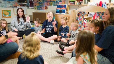 Adults and young children in a classroom.