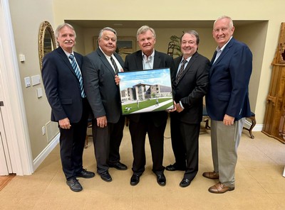 A group of people holding an architectural rendering.