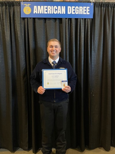 Wyatt Nebeker holding an FFA degree.