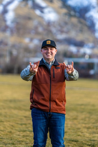 Wyatt Nebeker making horn signs with his hands.