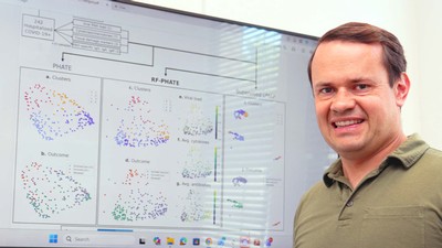 Data Scientist Kevin Moon at a large computer screen.