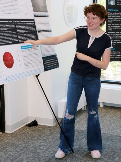 India Evans pointing to a research poster.