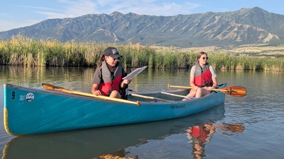 People canoeing in a marsh.