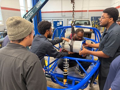 Students installing an electric motor in a vehicle.