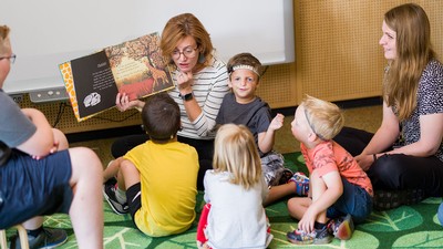 Teachers reading to children with hearing loss.
