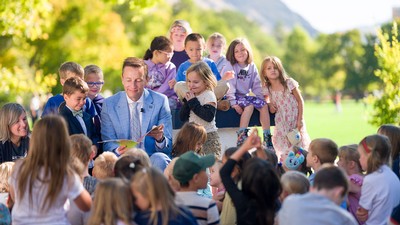 USU President Brad L. Mortensen reading with children.