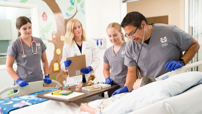 Nursing students working with a mannekin.
