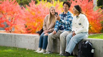 Students looking at a smartphone.