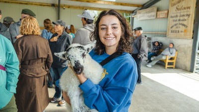 A person holding a lamb.