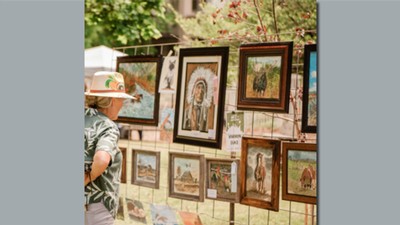 A person looking at art in an outdoor gallery.