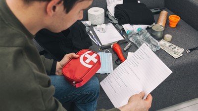 A person examining an emergency kit.